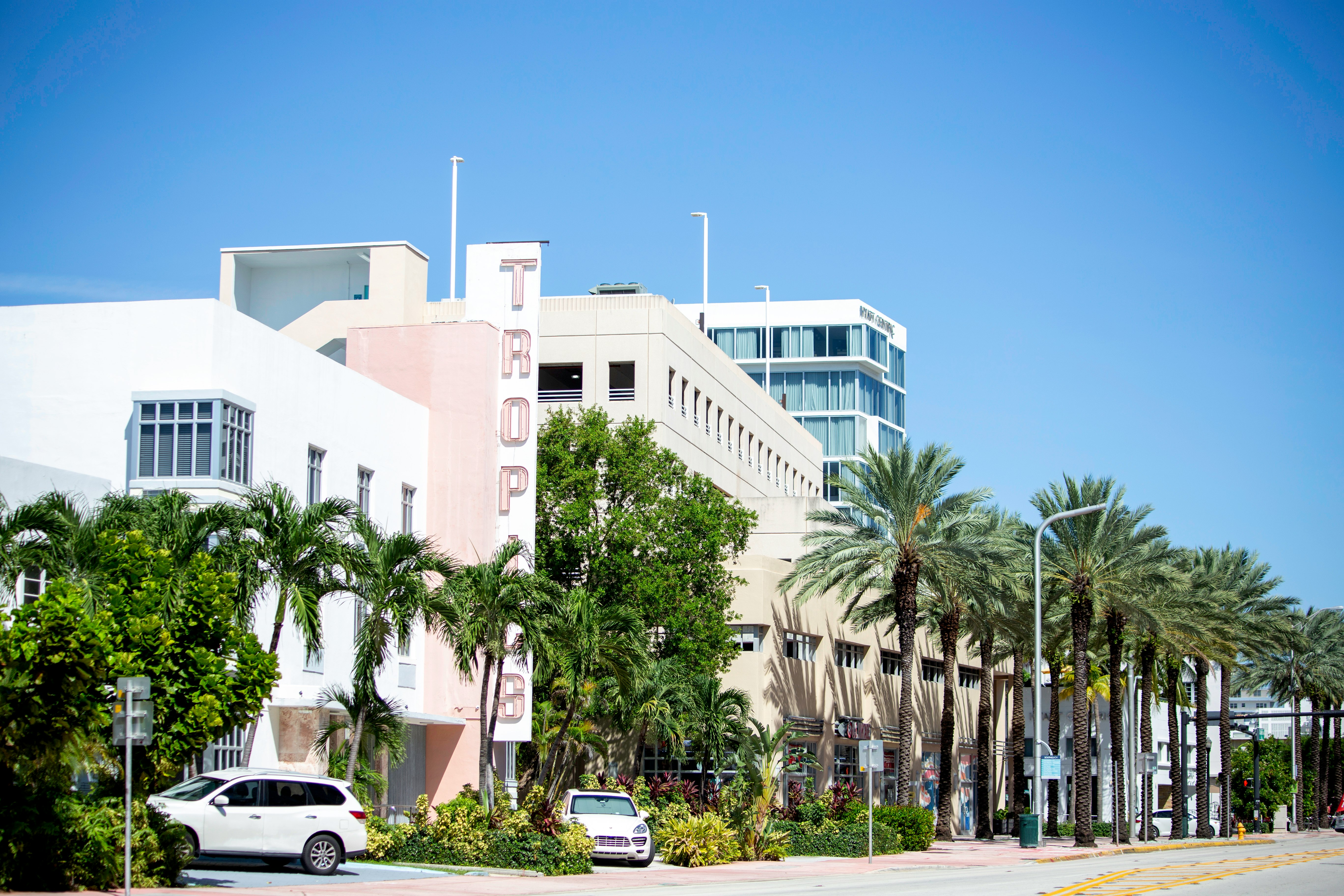 white concrete building near palm trees during daytime